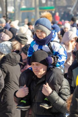 Petropavlovsk, Kazakistan - 06 Mart 2022: Kalabalıktaki çocuklara yakın çekim. Başla. Çocuklar gösteriyi izlemek için ailelerinin boynuna otururlar.