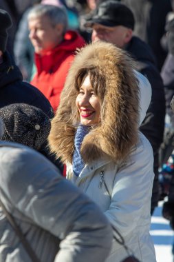 Petropavlovsk, Kazakistan - 06 Mart 2022: Kış güneşli bir günde kalabalığın içindeki insanların yüzleri.