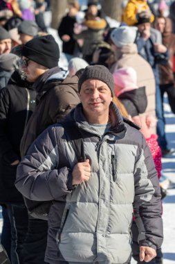 Petropavlovsk, Kazakistan - 06 Mart 2022: Kış güneşli bir günde kalabalığın içindeki insanların yüzleri.