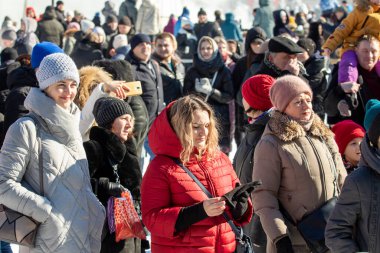 Petropavlovsk, Kazakistan - 06 Mart 2022: Kış güneşli bir günde kalabalığın içindeki insanların yüzleri.