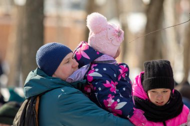 Petropavlovsk, Kazakistan - 06 Mart 2022: Kalabalıktaki çocuklara yakın çekim. Başla. Çocuklar gösteriyi izlemek için ailelerinin boynuna otururlar.