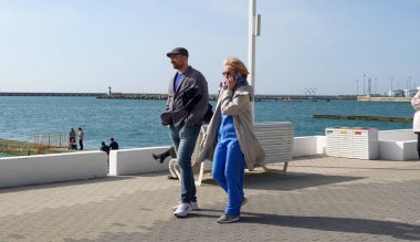 Soçi, Rusya - 27 Şubat 2022: Soçi şehrinin seddi, insanlar güneşli bir günde yürüyor.