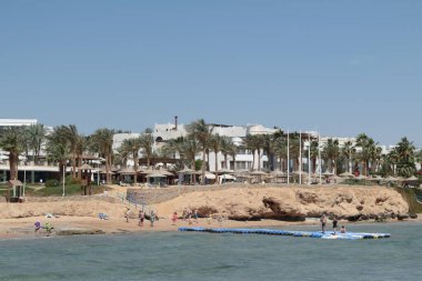 Sharm El Sheikh, Mısır - 10 Şubat 2022: Erkekler ve kadınlar yüzer ve güneşlenir, deniz manzarası.