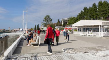 Soçi, Rusya - 27 Şubat 2022: Soçi şehrinin seddi, insanlar güneşli bir günde yürüyor.