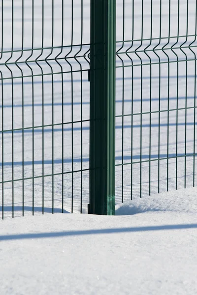 雪に覆われた緑の金属製のフェンス — ストック写真