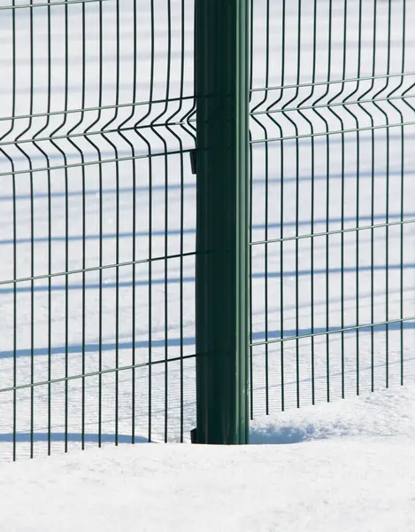雪に覆われた緑の金属製のフェンス — ストック写真