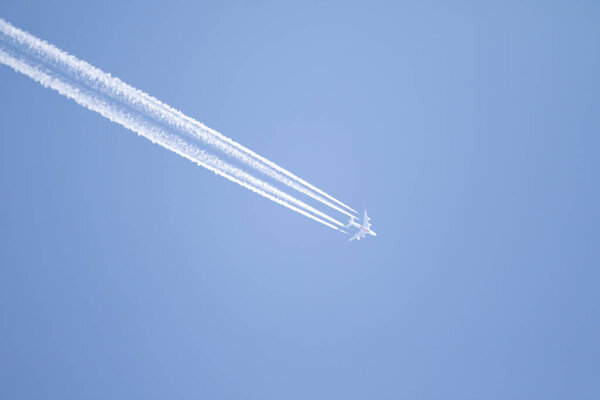 Голубое небо и след самолета высоко в небе.