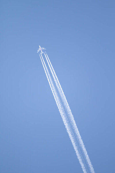 Голубое небо и след самолета высоко в небе.