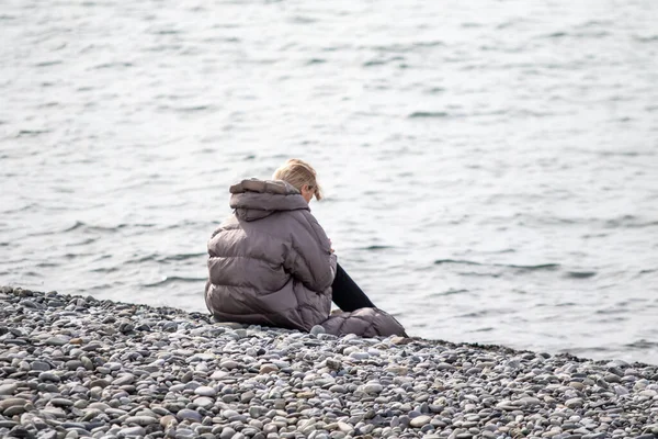 Soçi, Rusya - 23 Şubat 2022: İnsanlar güzel havalarda deniz kıyısında oturur. Barış zamanında.