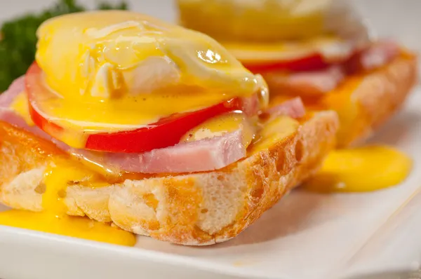 Eggs benedict on bread with tomato and ham — Stock Photo, Image