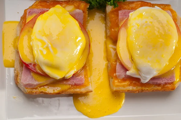 Eggs benedict on bread with tomato and ham — Stock Photo, Image