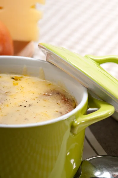 Суп с расплавленным сыром и хлебом сверху — стоковое фото
