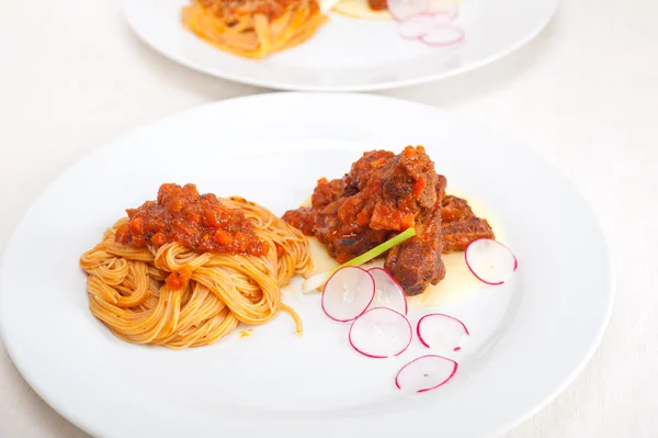 Pasta with pork ribbs sauce on polenta bed — Stock Photo, Image