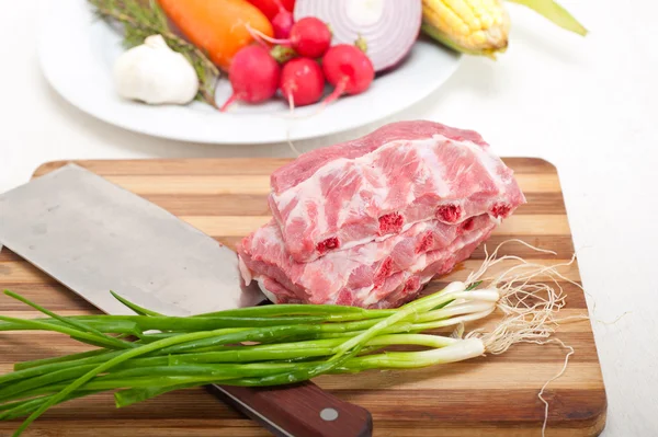 Chopping fresh pork ribs and vegetables — Stock Photo, Image