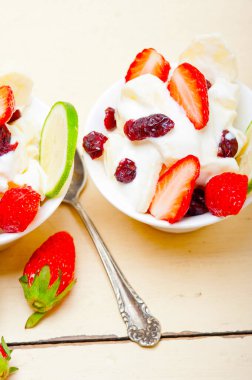 meyve ve yoğurt salatası sağlıklı kahvaltı beyaz ahşap masa üzerinde