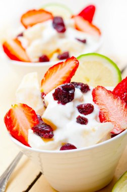 meyve ve yoğurt salatası sağlıklı kahvaltı beyaz ahşap masa üzerinde