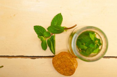 Taze nane yaprakları bir cam jarover bir rustik Beyaz ahşap masa