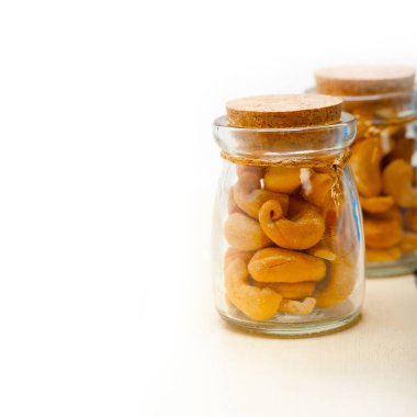 kaju fıstığı bir cam kavanoz içinde beyaz rustik ahşap masa üzerinde 