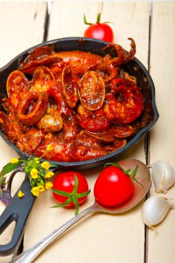 Demir tavada pişirilmiş taze deniz ürünleri güveci. 