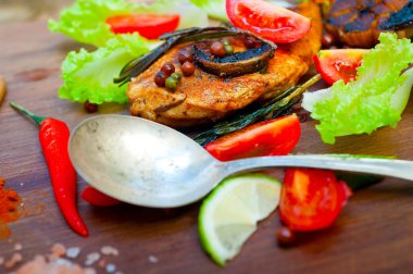 Ahşap kovuk ahşap güvertede tavuk göğsü pişirdi baharatlar ve sebzelerle.