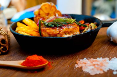 Kızarmış ızgara BBQ tavuk göğsü otlar ve baharatlarla demir tavada rustik stil