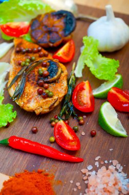 Ahşap kovuk ahşap güvertede tavuk göğsü pişirdi baharatlar ve sebzelerle.