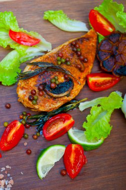 Ahşap kovuk ahşap güvertede tavuk göğsü pişirdi baharatlar ve sebzelerle.