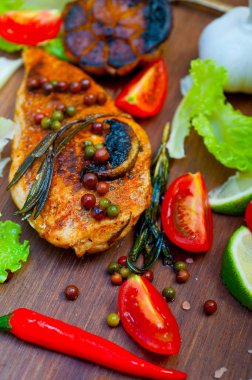 Ahşap kovuk ahşap güvertede tavuk göğsü pişirdi baharatlar ve sebzelerle.