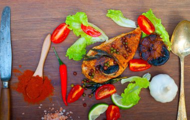 Ahşap kovuk ahşap güvertede tavuk göğsü pişirdi baharatlar ve sebzelerle.