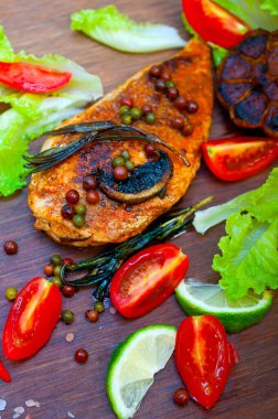 Ahşap kovuk ahşap güvertede tavuk göğsü pişirdi baharatlar ve sebzelerle.