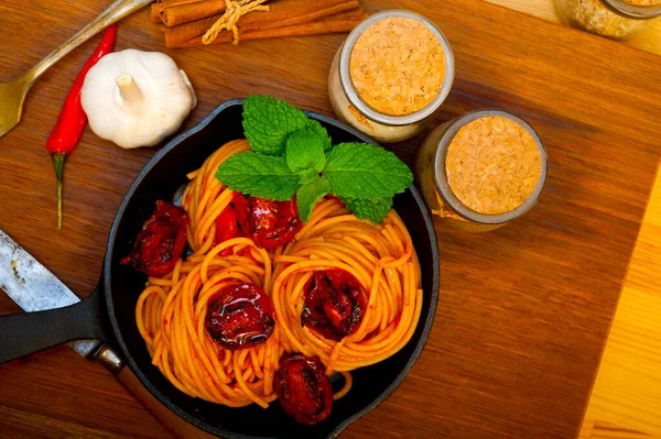 Italiaanse Spaghetti Pasta Tomaat Met Muntblaadjes Ijzeren Koekenpan Houten Plank — Stockfoto