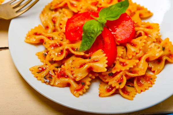 意大利面食厨蝴蝶领结在白色仿古木桌番茄罗勒酱 — 图库照片