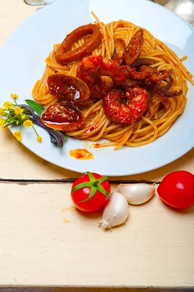 白い素朴な木製のテーブルの上の赤いトマトソースのイタリアン シーフード スパゲッティ パスタ — ストック写真