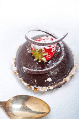 Taze çikolatalı, çilekli, beyaz üzerine gümüş kaşıklı mus.