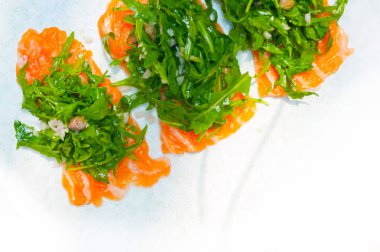 taze Somon carpaccio suşi sashimi roka roket salata ve üstte Kapari