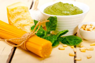 İtalyan geleneksel fesleğen pesto makarna malzemeleri parmesan peynirçam fıstığı sızma zeytinyağı sarımsak rustik bir masada 