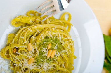 İtalyan geleneksel fesleğen pesto makarna malzemeleri parmesan peynirçam fıstığı sızma zeytinyağı sarımsak rustik bir masada 