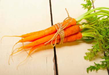 taze bebek havuç demet rustik bir masada ip ile bağlı