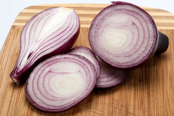 Red onions on a wooden board — Stock Photo, Image