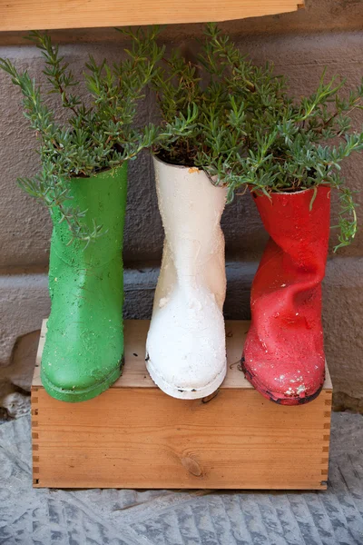 Vecchie scarpe lavorate su vasi da fiori — Foto Stock