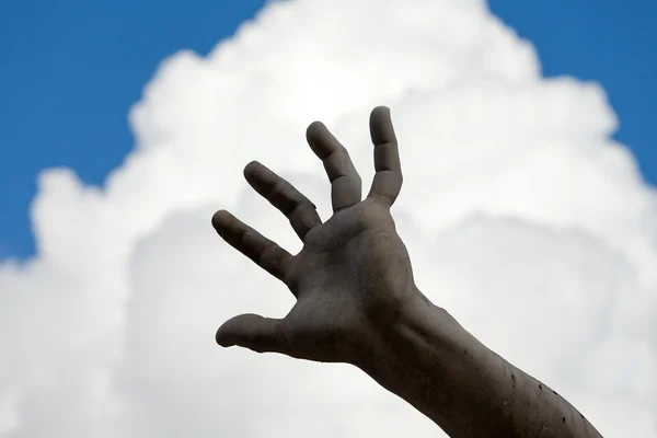 The stony hand against the background of the sky.