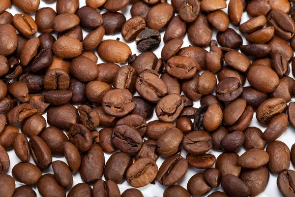 Chicchi di caffè da vicino isolati su bianco — Foto Stock