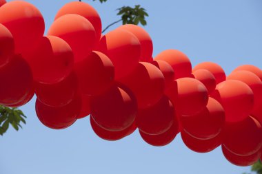 Kırmızı balonlar sokak üzerinde asılı