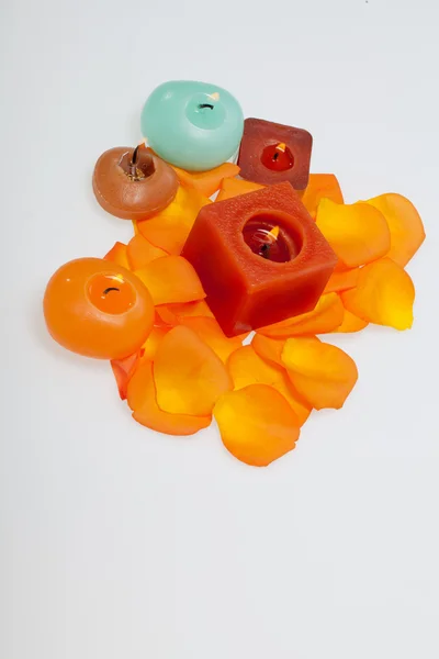 Petale vărsate de trandafir portocaliu în jurul lumânării aromatice — Fotografie, imagine de stoc