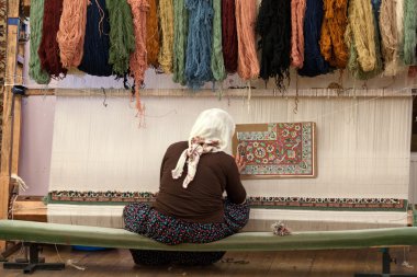 Türk kadın ipek halı örüyor.