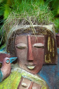 Çiçek saksısı kadınsı kafa şeklinde.