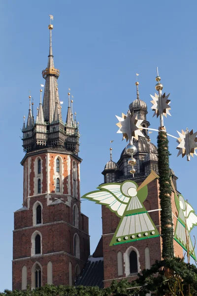 Weihnachtsdekoration mit Trompetenspiel auf dem Hauptmarkt in Krakau zur Weihnachts- und Neujahrszeit, im Hintergrund Mariacki-Kirche, Krakau, — Stockfoto