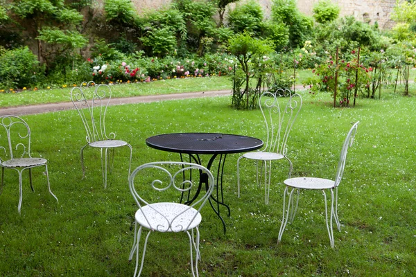 La table vide et quatre chaises blanches dans le jardin — Photo