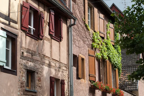 Ulice s poloroubenými středověkými domy ve vesnici Eguisheim podél slavné vinařské stezky v Alsasku, Francie — Stock fotografie