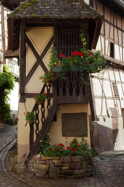 Utca félgerendás középkori házakkal Eguisheim faluban a híres borút mentén Elzászban, Franciaországban — Stock Fotó